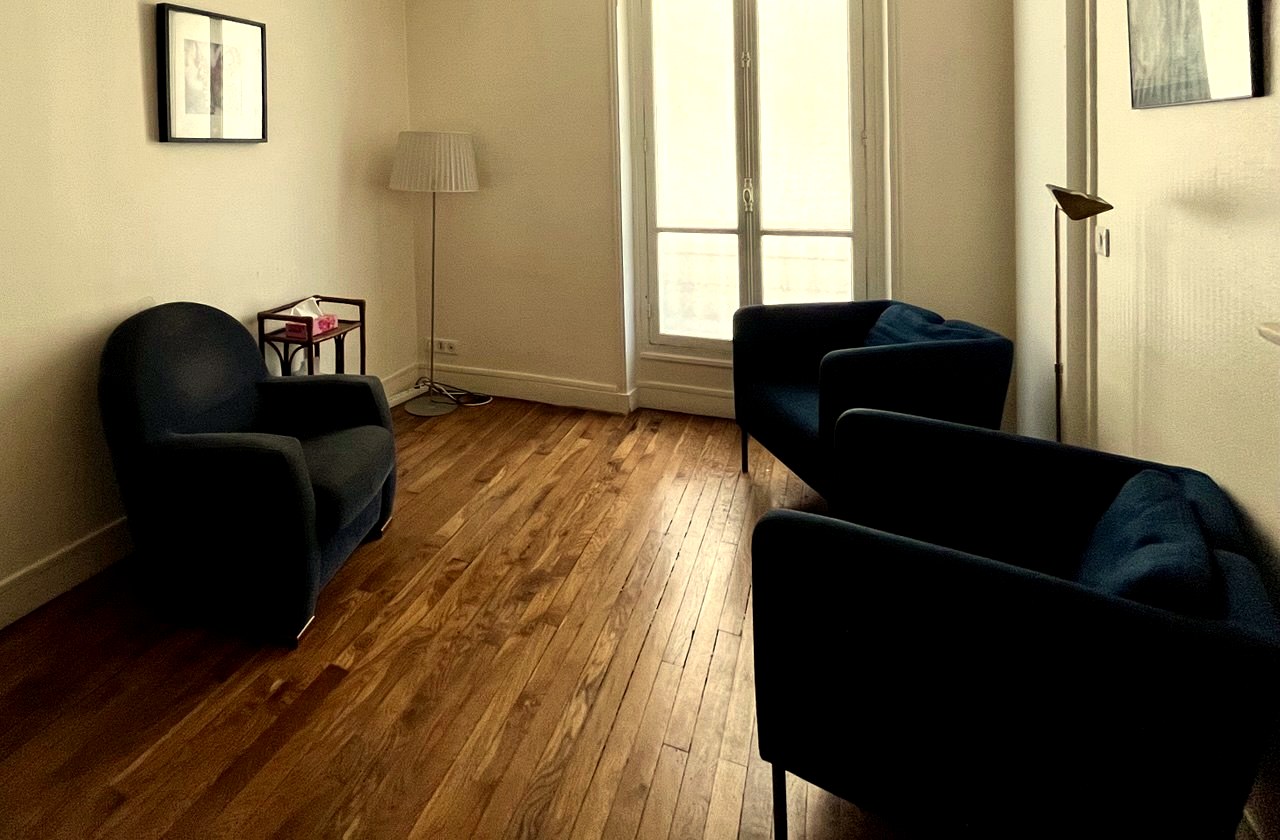 Le cabinet : fauteuils, parquet, lumière de la fenêtre.